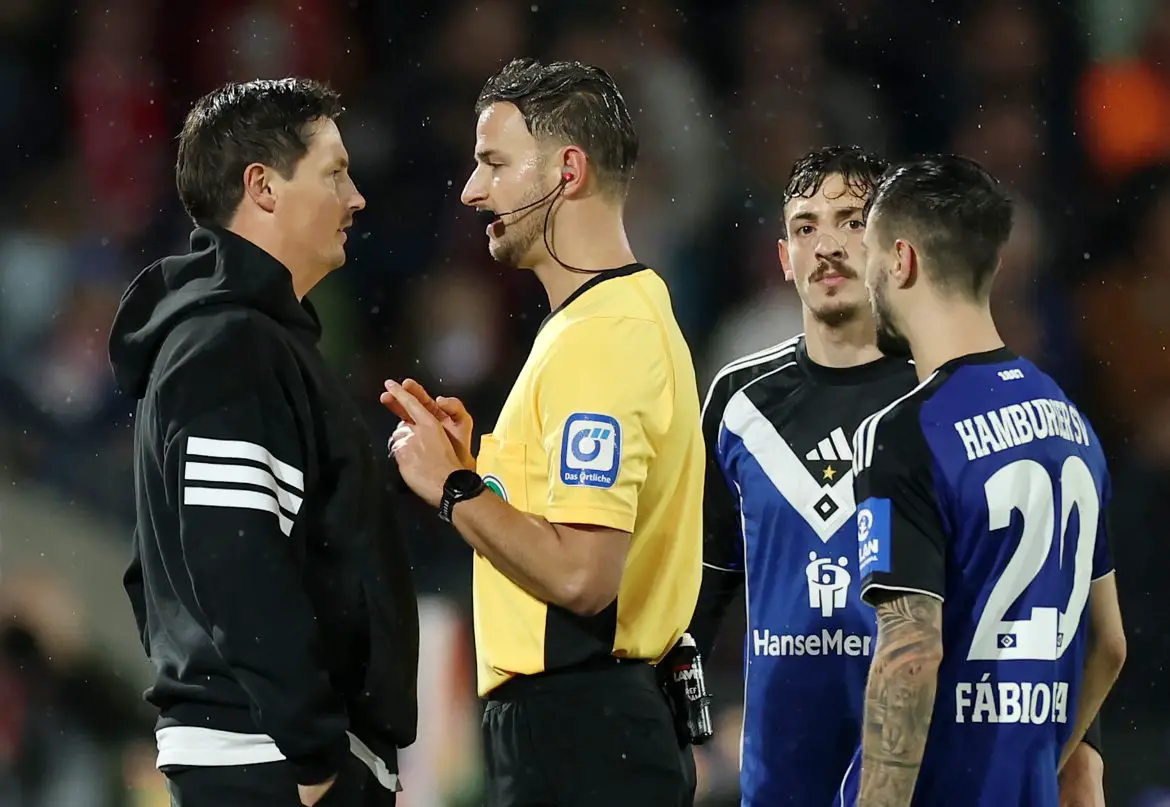 Bundesliga match official Daniel Schlager (right) speaking to Hamburg head coach Merlin Polzin (left) during the Köln-Hamburg match last night.