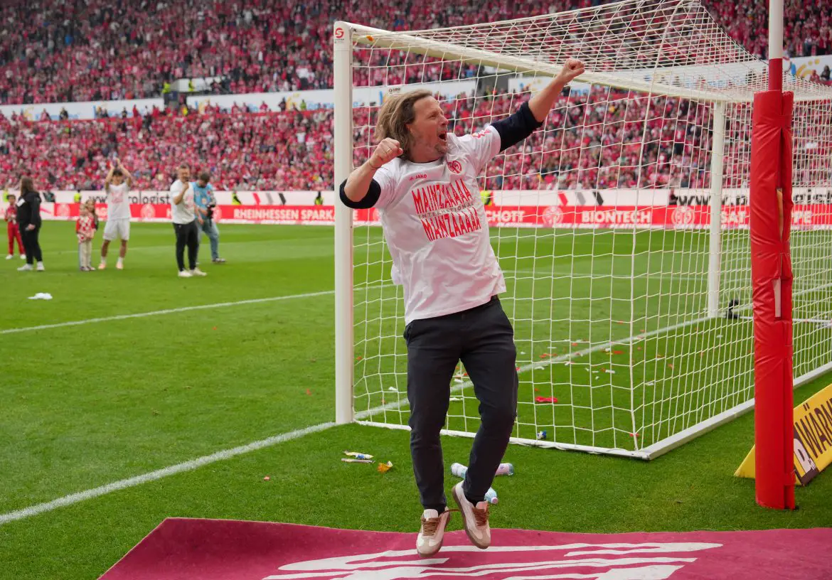 FSV Mainz 05 head coach Bo Henriksen - donning a special T-shirt - celebrates Mainz 05's Europa League qualification in front of the FanKurve yesterday.