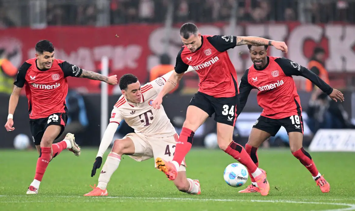Jamal Musiala (Bayern Munich) and Granit Xhaka (Bayer Leverkusen) battle for the ball in a Bundesliga match.
