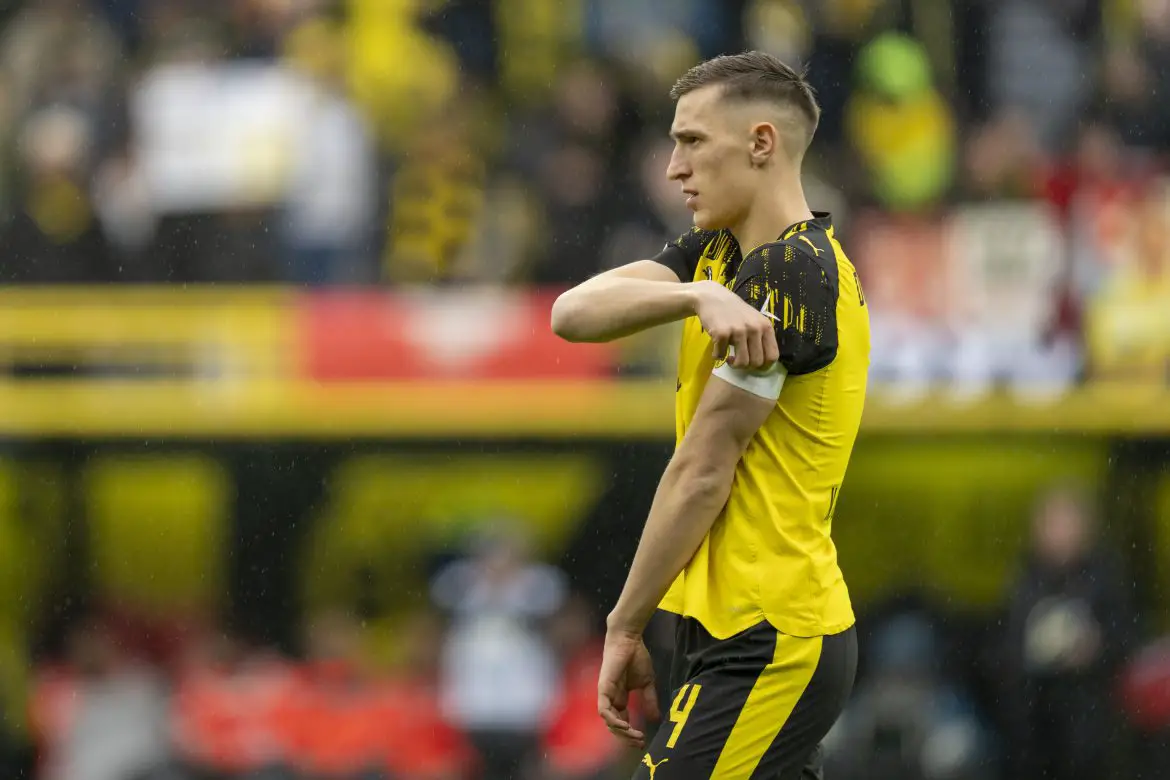 Borussia Dortmund's Nico Schlotterbeck adjusts his captain's armband during Saturday's Bundesliga match against Augsburg.