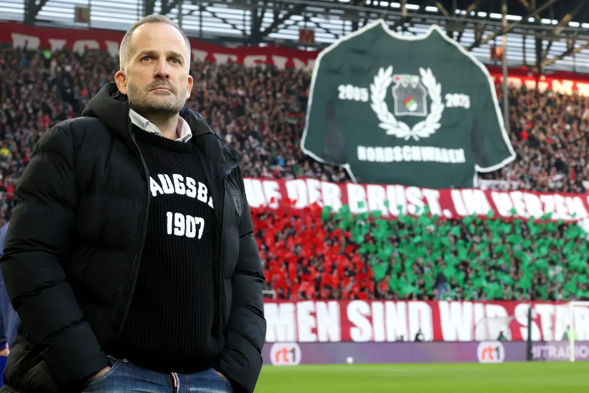 Augsburg head coach Manuel Baum stands before the FanKure in the Bundesliga.