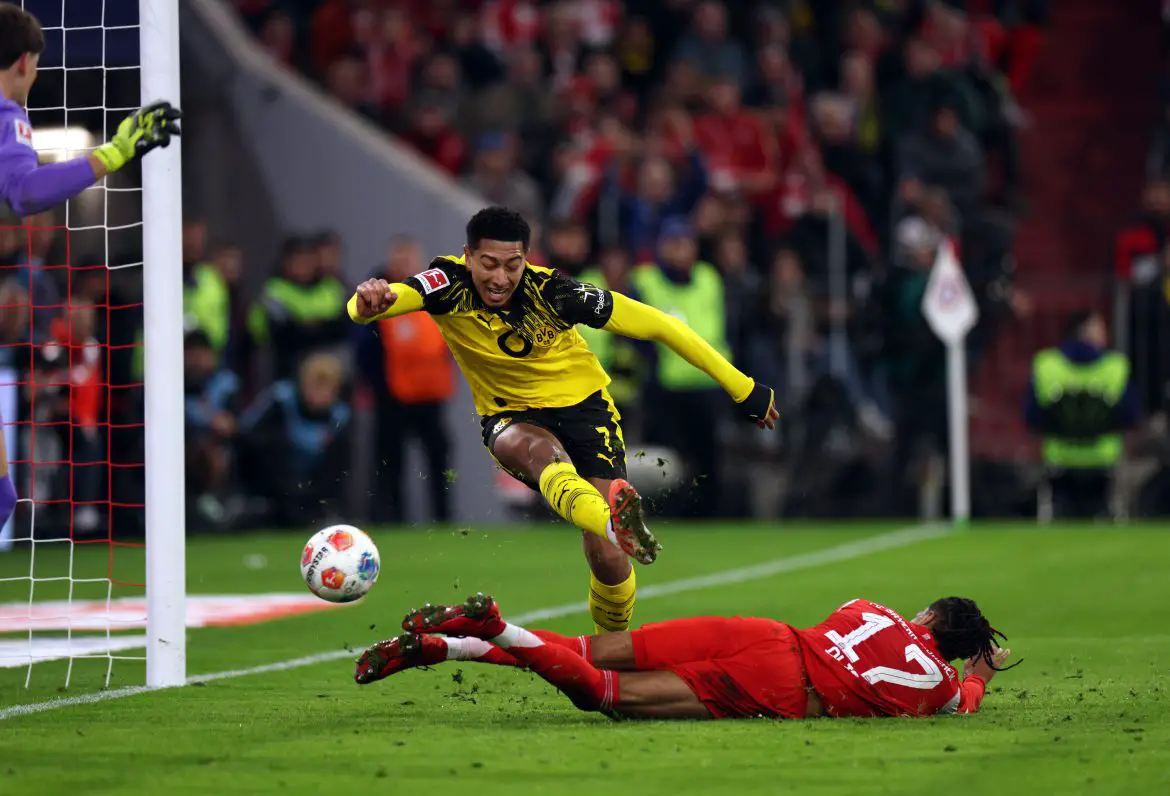 Bayern Munich's Michael Olise scoring past Borussia Dortmund's Jobe Bellingham in Saturday evening's Bundesliga Top-Spiel.