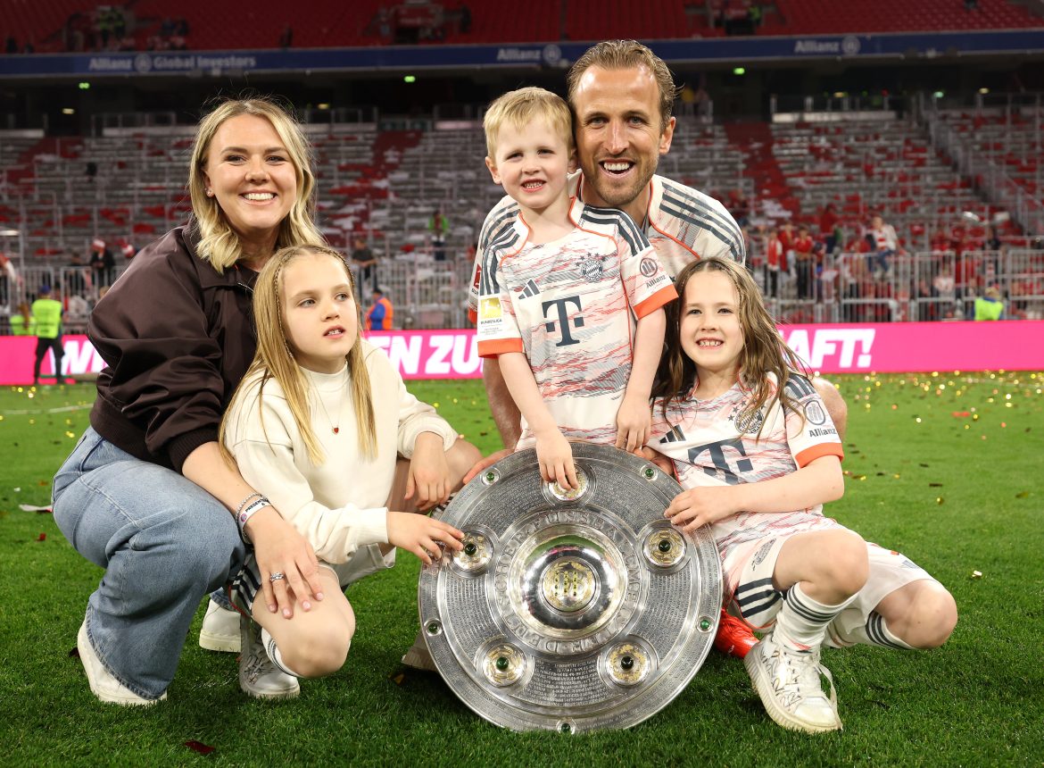 Harry Kane and his family pose with the Bundesliga Mesiterschale trophy.