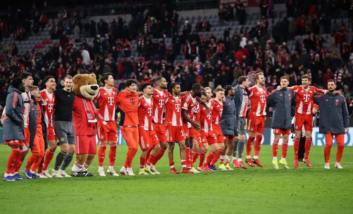 Bayern Munich players celebrate their DFB Pokal victory over RB Leipzig in front of the Allianz Arena SüdKurve.