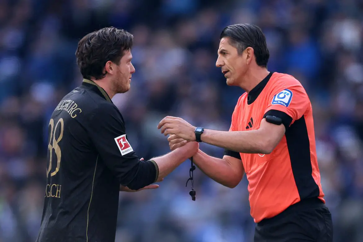 Augsburg's Michael Gregoritsch (left) discusses a scene with match official Deniz Aytekin during Saturday's crucial relegation six-pointer against Hamburg.
