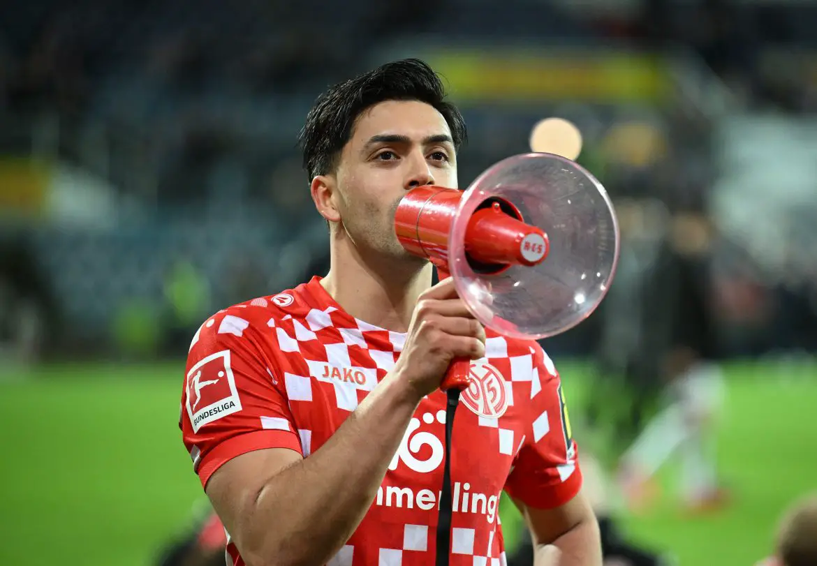 Nadiem Amiri addressing Mainz fans with a megaphone following a Bundesliga match.