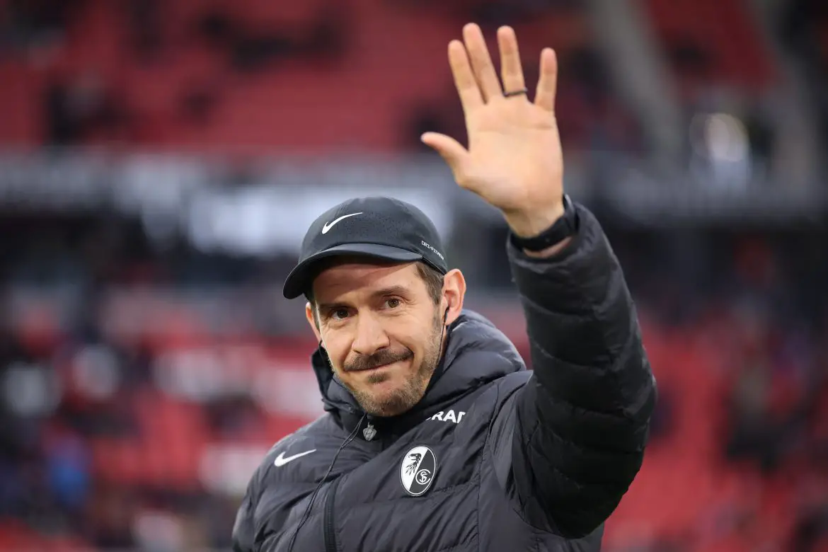 SC Freiburg head coach Julian Schuster acknowledges fans ahead of a home Bundesliga match.