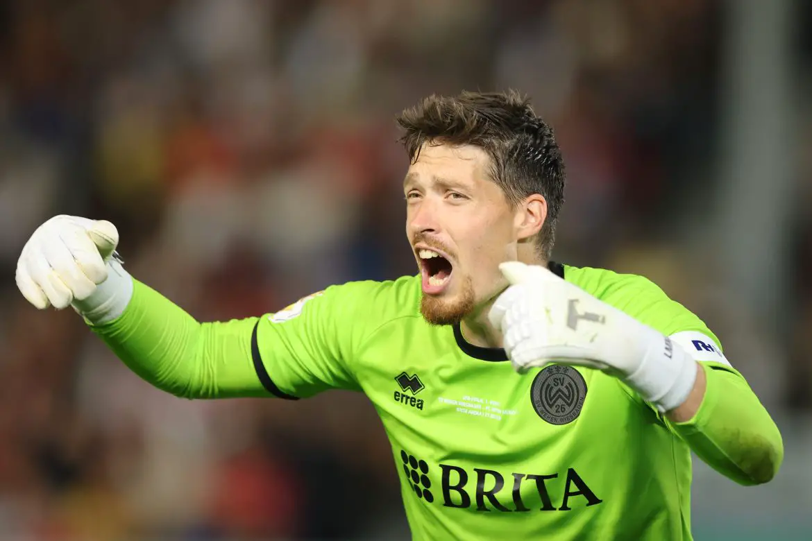 Florian Stritzel celebrates saving a Harry Kane penalty in the DFB Pokal.