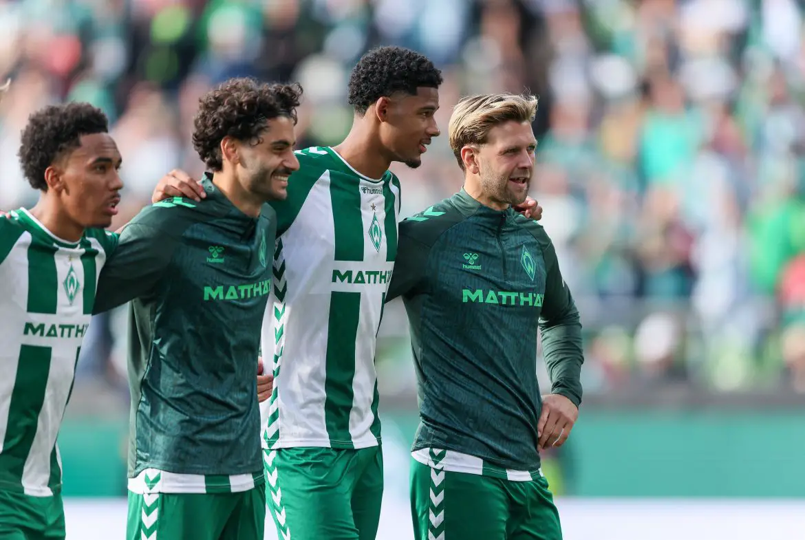 Eren Dinkçi (second from left) celebrates a Bundesliga win with his club teammates.