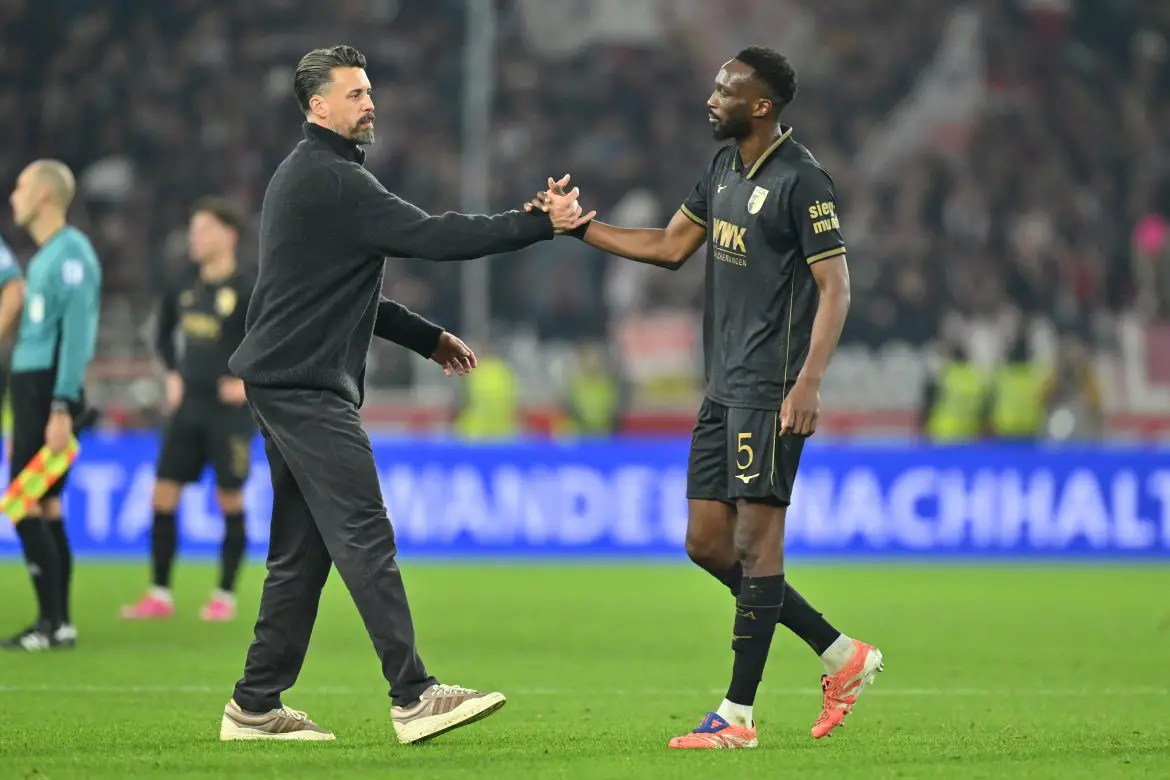 Augsburg defender Chrislain Matsima (right) shakes hands with former FCA head coach Sandro Wagner (right) in the Bundesliga.
