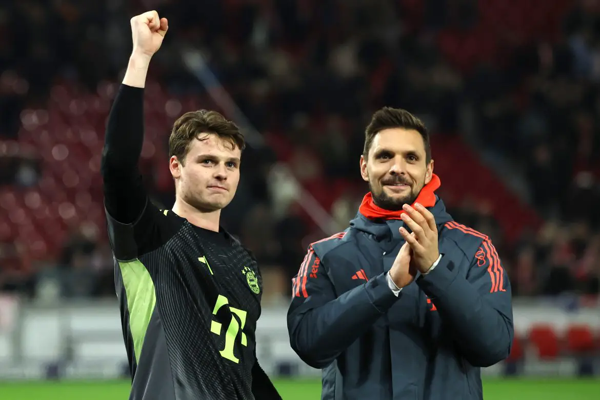 Bayern Munich goalkeepers Jonas Urbig (left) and Sven Ulreich (right) celebrate a Bundesliga victory over Stuttgart.